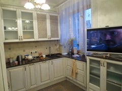 Результат - белая П-образная кухня. Отдельная тумба под плазменный телевизор. Удачно используется  место у окна - гармоничное продолжение кухни.